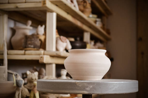 istock Clay pot in the foreground and shelves with pottery - on the second 695576664