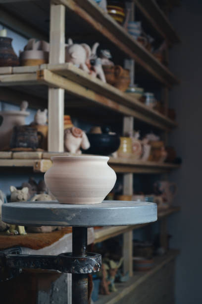 istock Clay pot in the foreground and shelves with pottery - on the second 695576768