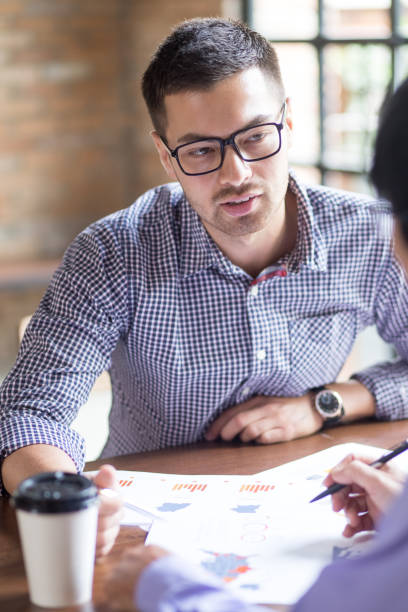istock Closeup of Colleagues Discussing Diagram 695580494