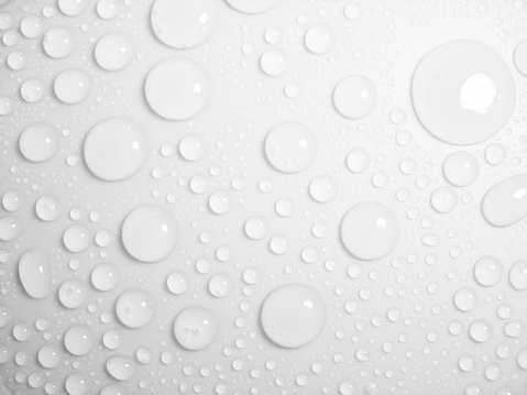Clean clear water drop background on a bright white surface