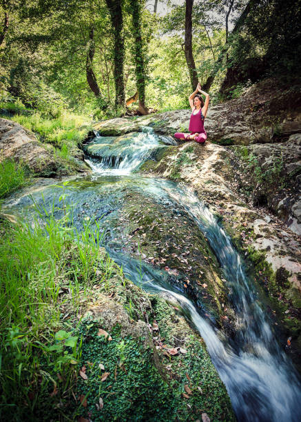 istock Young woman practicing yoga in nature: meditation posture 695582356