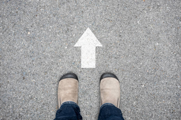istock Brown suede shoes and go forward direction sign 695582432