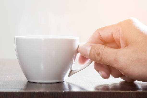 istock Cup of hot coffee on wooden table 695582548
