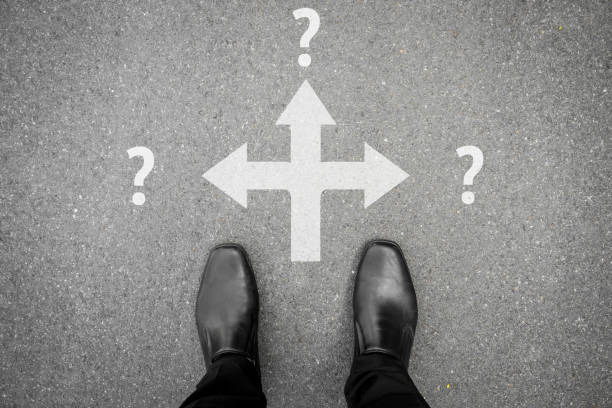 istock Black shoes making decision at three ways crossroad 695582562
