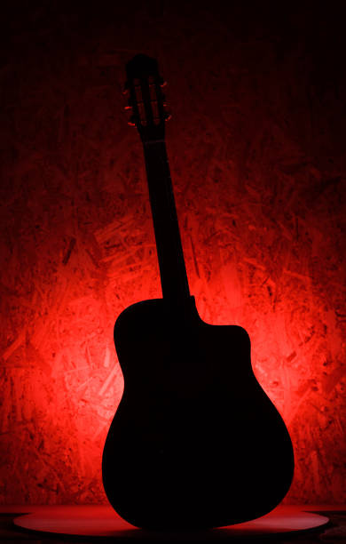 istock the silhouette is the classic acoustic guitar on a red background 695585040