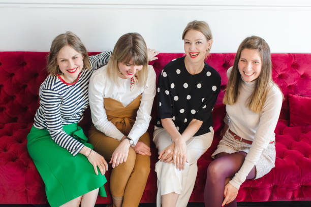 istock Cheerful women sitting on couch 695585804