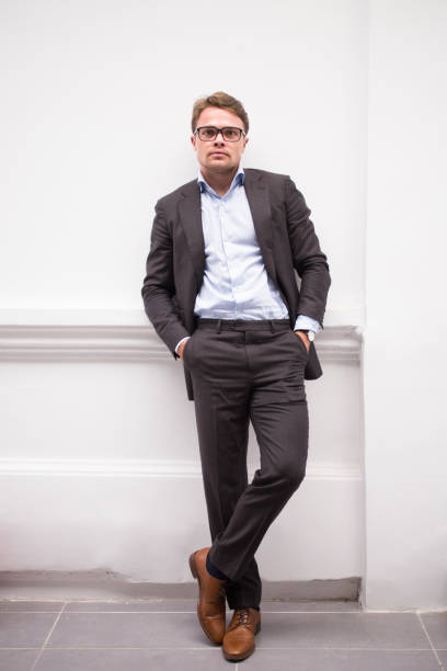 imprenditore maschio alla moda in posa per la macchina fotografica - pocket suit glasses jacket foto e immagini stock