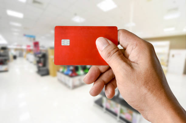 istock a hand holding credit card blurred electronics store 695589590