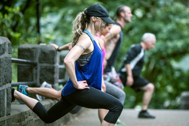 Outdoor Fitness Class A boot camp type exercise class meets outdoors, the group made up of a diverse mix of ages and ethnicities. sports training drill stock pictures, royalty-free photos & images