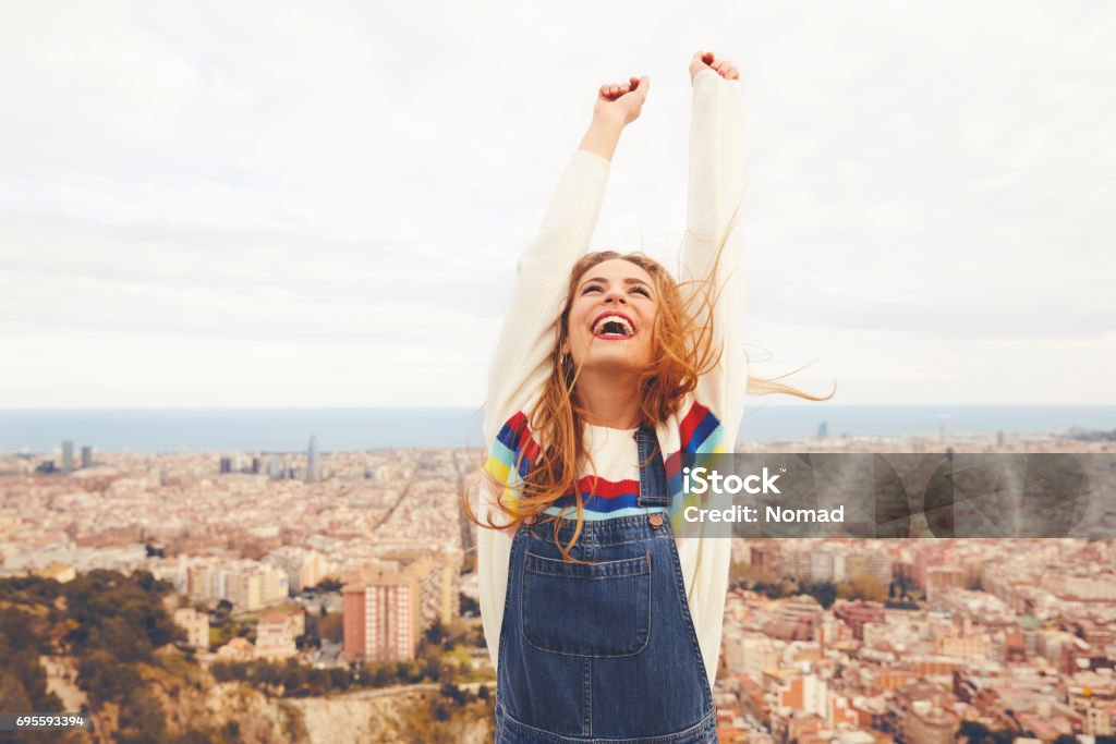 Mujer feliz con los brazos alzados contra el paisaje urbano - Foto de stock de Felicidad libre de derechos