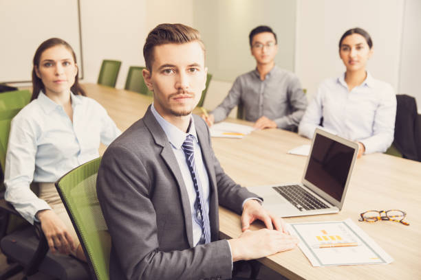 istock Serious businessman sitting team in boardroom with 695593650