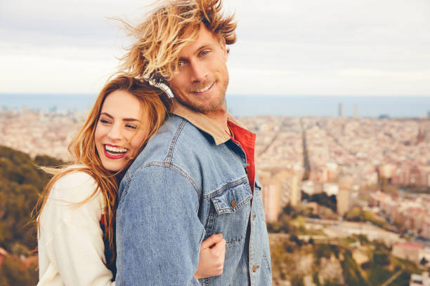 istock Smiling couple embracing against cityscape 695596016