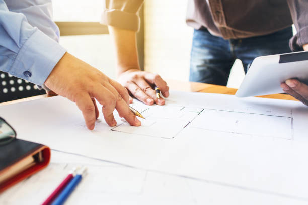 istock Architecture engineering teamwork meeting at workplace to plan drawing a new blueprint busy working hard for apartment building small business of their customer service. 695596904