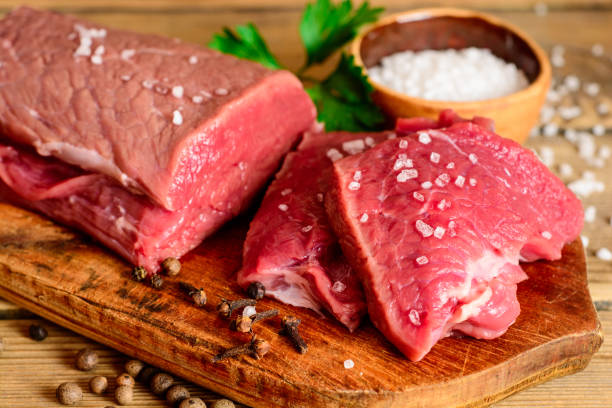 istock Raw beef meat on rustic wooden cutting board. 695597776