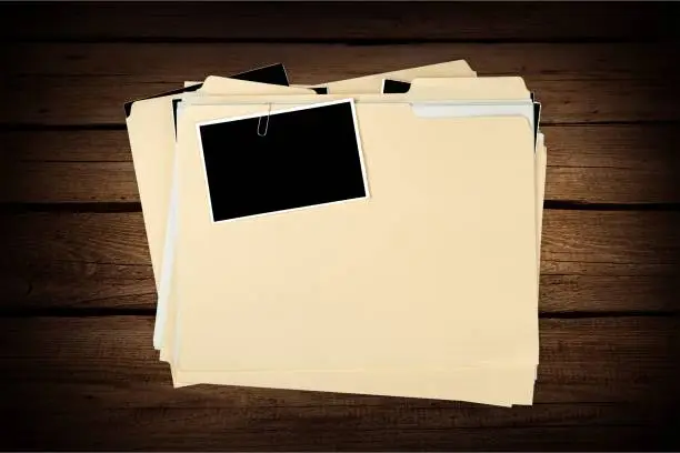 Stacked yellow file folders on wooden background