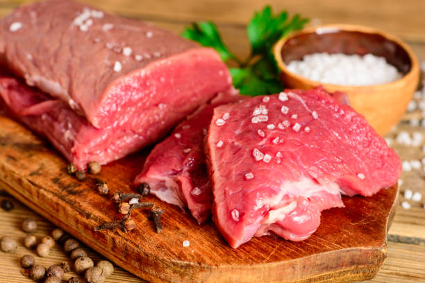 istock Raw beef meat on rustic wooden cutting board. 695597894