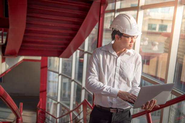 istock Young Asian Engineer or Architect working with laptop 695605064