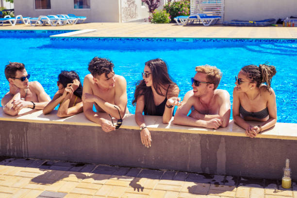 istock cheerful friends drinking cocktails in the pool 695608962