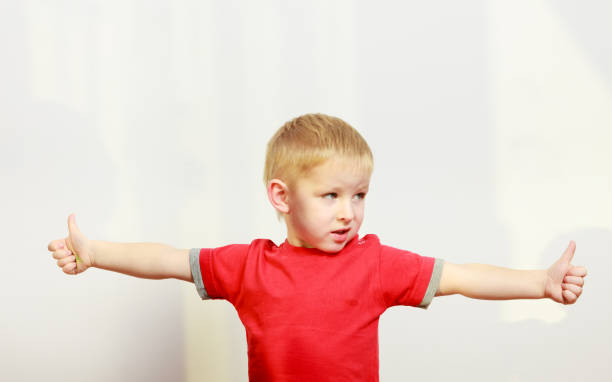 istock Little boy playing showing thumb up gesture 695616290