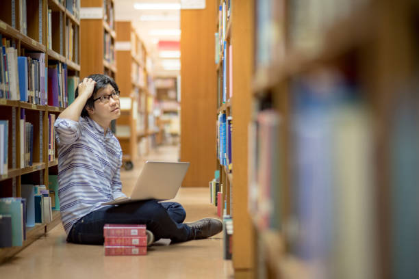 istock Young Asian man university student thinking about his project homework 695618986