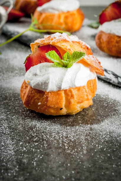 istock Profiteroles with whipped cream, strawberries and mint 695619656