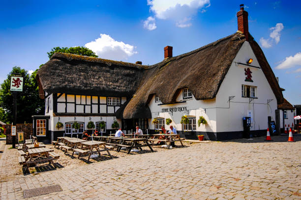 personas fuera del pub red lion en avebury en wiltshire, reino unido - english pub fotografías e imágenes de stock