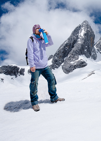 Climber breathing with mini portable oxygen cylinger to avoid and treat Altitude Sickness synptom