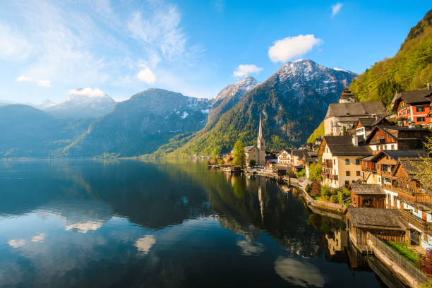 Hallstatt Village and Hallstatter See lake in Austria Scenic nature landscape view of Hallstatt mountain village reflecting in Hallstatter see lake against The Austrian Alpines in with morning sunshine and beautiful blue cloudy sky looking like a postcard picture in Salzkammergut region, Austria xxxl size april 2017 dachstein mountains photos stock pictures, royalty-free photos & images