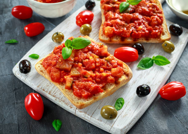 świeże domowe chrupiące włoskie przekąski bruschetta zwieńczone pomidorem, bakłażanem, cukinią, żółtą papryką, czosnkiem i bazylią na białej drewnianej desce. zdrowa żywność - mediterranean cuisine salad olive oil tomato salad zdjęcia i obrazy z banku zdjęć