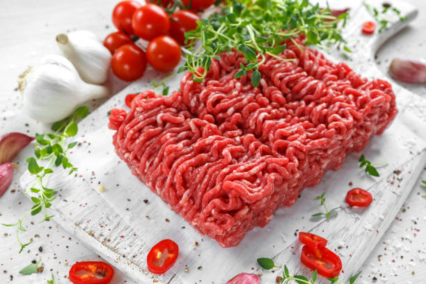 istock Fresh Raw Beef Minced Meat with salt, pepper, chilli and fresh thyme on white board. 695636788