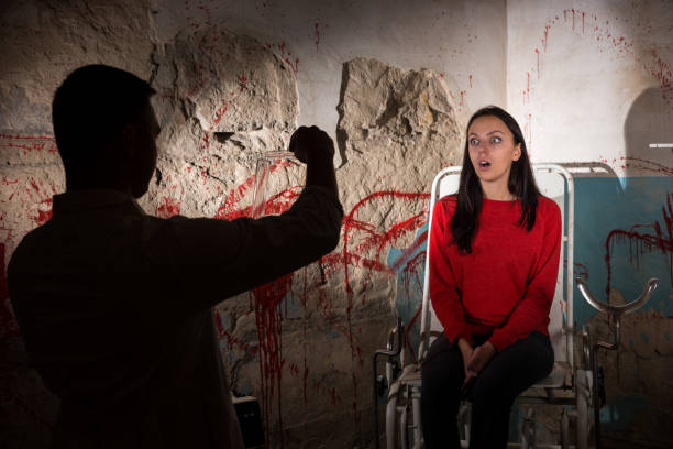 istock Shadowy figure pours liquid from beakers in front of patient 695637552