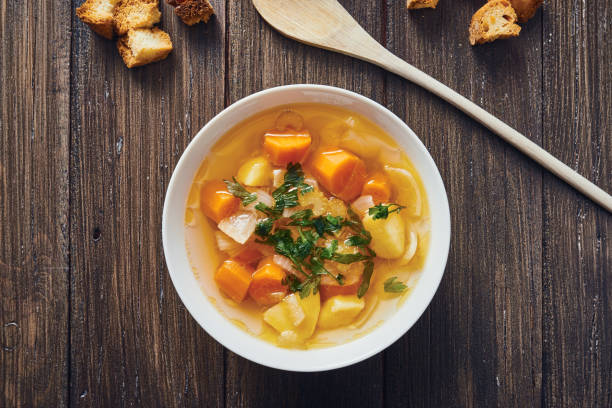 zuppa di verdure in ciotola bianca su tavolo di legno - stuffing celery onion spoon foto e immagini stock