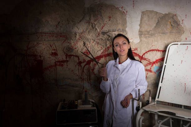 istock Female scientist holding large iron scissors in dungeon 695637698