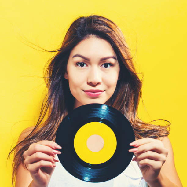 istock Happy young woman holding a record 695641298