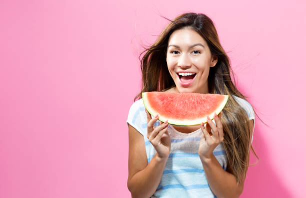 istock Happy young woman holding watermelon 695641390
