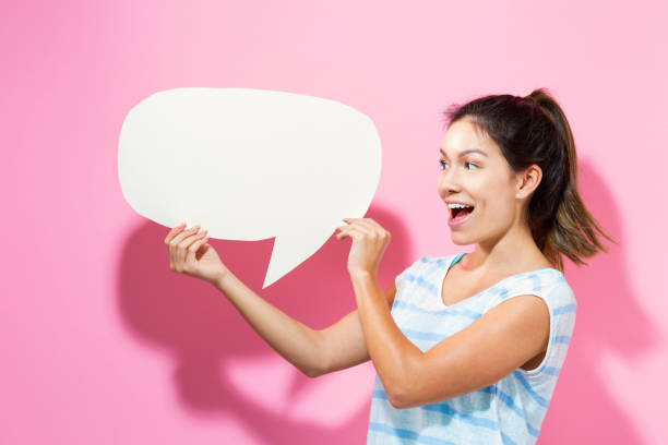 istock Young woman holding a speech bubble 695641496