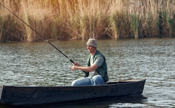 istock fisherman- young man fishing on river 695644224