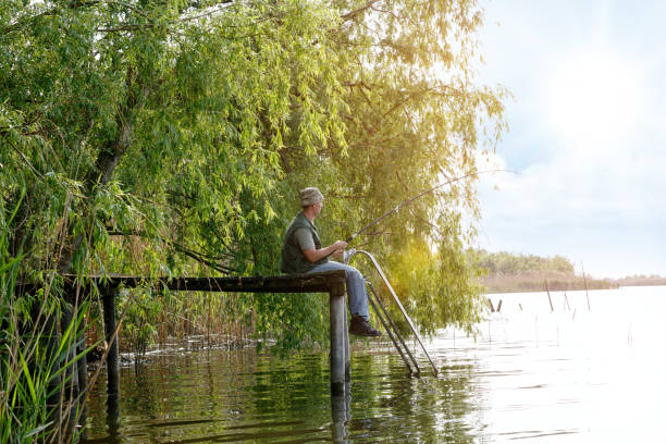 istock man with fishing rod catching fish 695644324