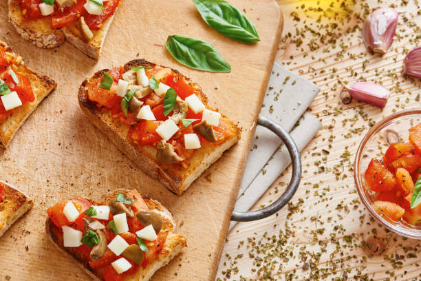 istock Bruschetta tomato, cheese, olives and garlic on cutting board 695645350