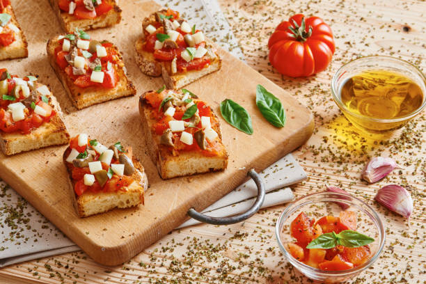 istock Bruschetta tomato, cheese, olives and garlic on cutting board 695645396