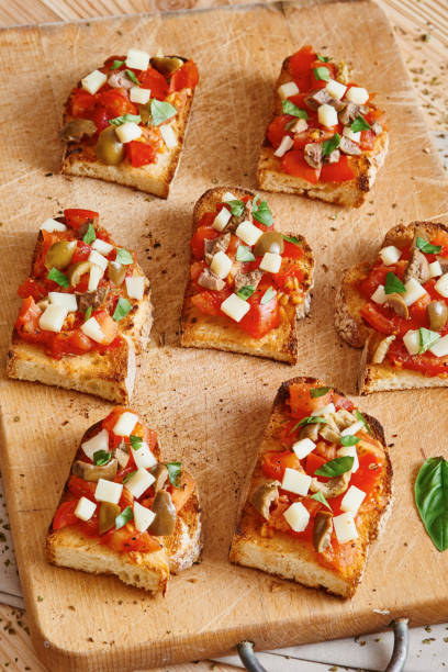 istock Bruschetta tomato, cheese, olives and garlic on cutting board 695645398