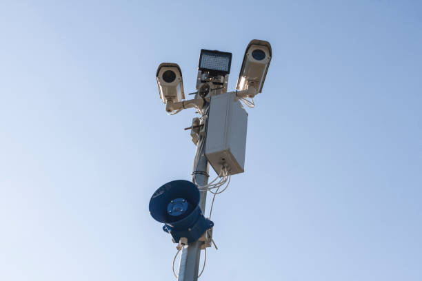 istock Surveillance CCTV security cameras on blue sky background with megaphone 695646384