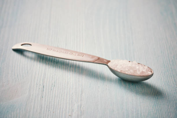 istock Measuring spoon with salt on wooden table blue 695648614