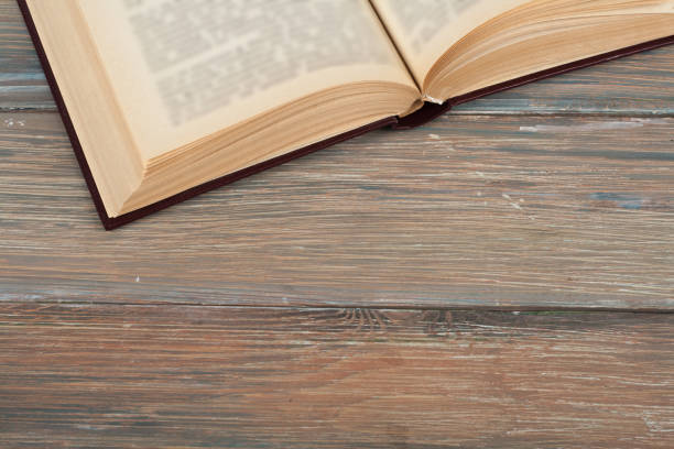 istock Vintage book, open, on old wooden table 695649488