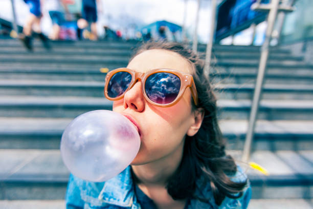 istock Woman portrait blowing a bubble chewing gum 695652192
