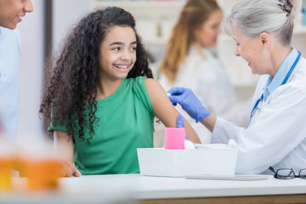 istock Mixed race girl receives back to school immunizations 695656414