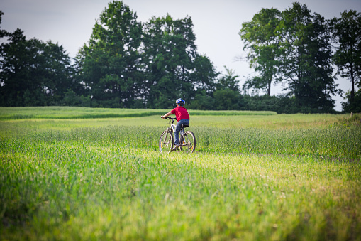 boy ride on bike on rural landscape, outdoors