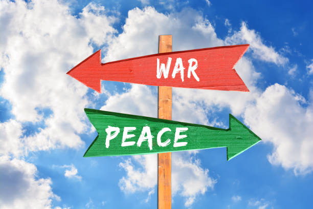 istock War versus peace on wooden directional sigh against blue sky 695657132