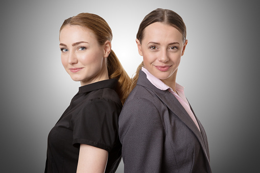 Deal! Close-up of two businesswomen shaking hands against an office backgrounds. Focus on hands