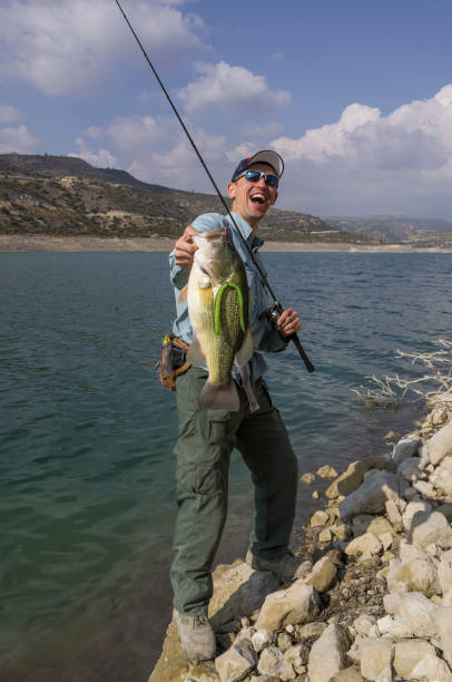 istock Fisherman with bass trophy 695662862